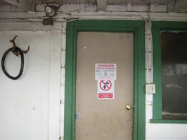 A sign posted by county health officials warns that the Pescadero barracks occupied by farm laborers and their families is uninhabitable on May 20, 2010.
